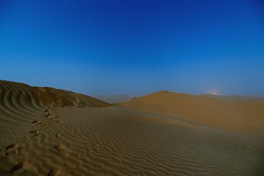 At the Crack of Dawn (Rub al-Khali, Oman) Bei Sonnenaufgang in der Wüste Rub al-Khali: Die Luft ist staubig vom letzten Sandsturm. Während sich im Osten die Sonne bereits ankündigt, leuchtet der fast...